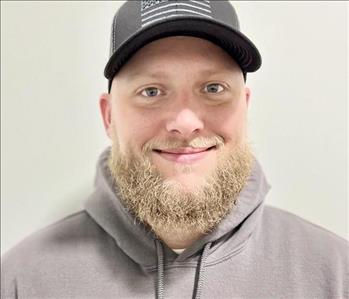 Male head shot, wearing a hat, has a blond beard and smiling.