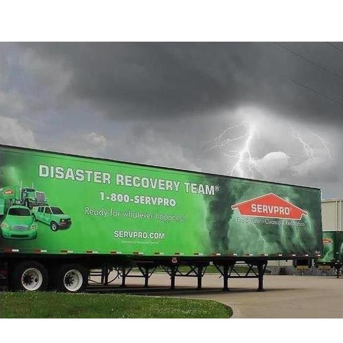 Storm cloud with lightening with a SERVPRO Disaster trailer set up to help the community.