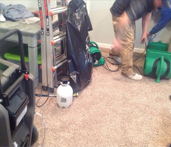 Technicians work to strategically place air movers in order to achieve the best possible drying environment