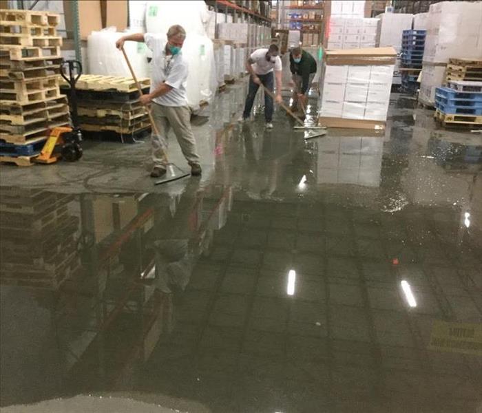A crew works to clean up a large water loss at a factory 